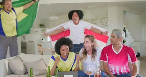 Diverse friends huddling on couch watching tablet celebrating goal swapping Stock Footage 340774300