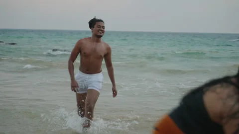 Diverse friends laugh, splash in ocean waves. Inclusive group enjoys beach fun Stock Footage 269339999