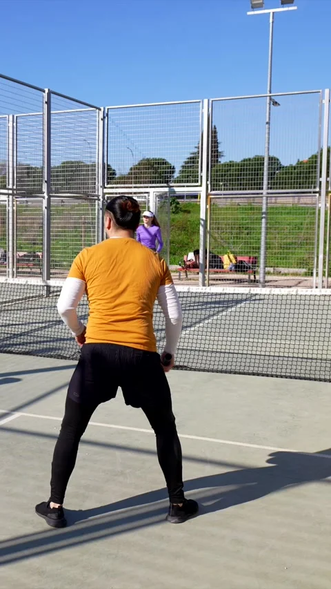 Diverse friends playing pickleball doubles on an outdoor court Stock Footage 334009835