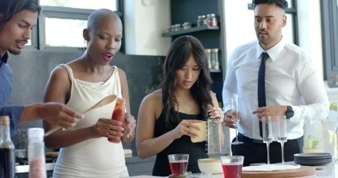 Diverse friends pointing, making pizza on board at island, grating cheese, Stock Footage 338062995