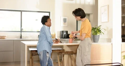Diverse friends preparing coffee at kitchen island exchanging grounds jar and Stock Footage 342112253