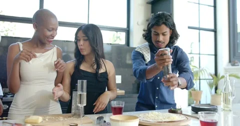 Diverse friends reaching food, adding toppings, grinding pepper on pizza at loft Stock Footage 339162142