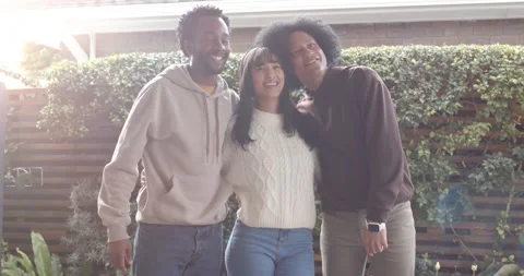 Diverse friends reacting to camera, posing in backyard, woman centering, men Stock-Footage 345618342