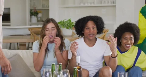 Diverse friends sitting couch watching offscreen action as woman coming left Stock Footage 340774291