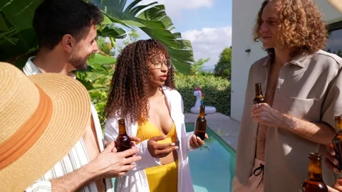 Diverse friends socializing and drinking beer at a summer pool party 動画素材 335405407