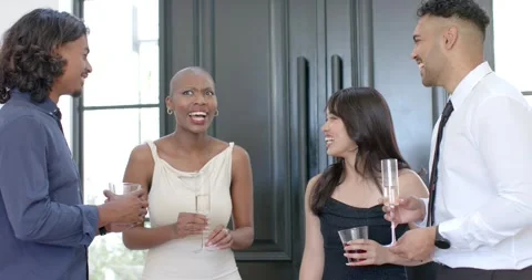 Diverse friends socializing in kitchen, left man gesturing, group raising Stock Footage 342493281