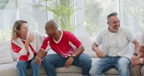 Diverse friends socializing on light sofa, man in stripes leaning, sparking Stock Footage 341320846