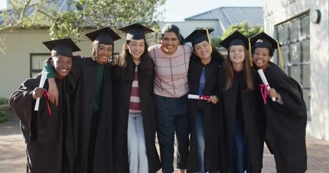 Diverse graduates linking arms, fixing caps on campus as camera pulling back, Stock Footage 341063786