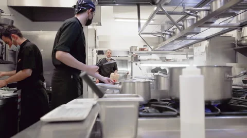 Diverse group of chefs preparing food in restaurant kitchen. Working in a busy Stock Footage 166539875