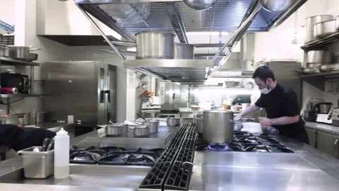 Diverse group of chefs preparing food in restaurant kitchen. Working in a busy Stock Footage 166744920