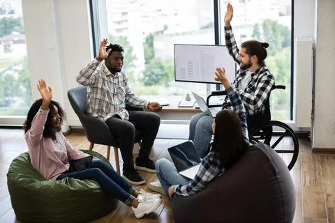 Diverse group collaborating in modern setting, working on inclusive teamwork Stock Photos