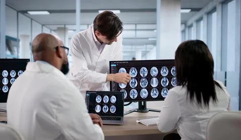 Diverse Group Of Doctors And Technicians Study Brain MRI Scans Together. Medi Stock Photos