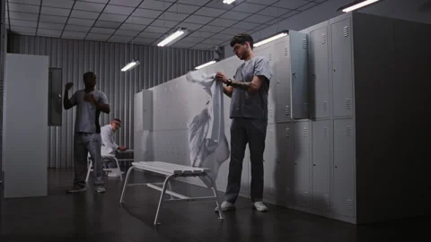 Diverse Group of Doctors Changing Clothes in Hospital Locker Room After Long Stock Footage 334011865