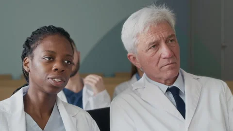 Diverse Group of Doctors Consulting during Medical Seminar in Auditorium Stock Footage 308520808