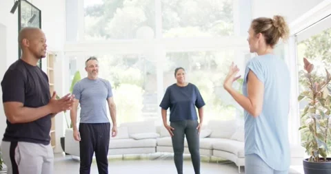 Diverse group following instructor gesturing, speaking in studio, learning Vidéo 340982218