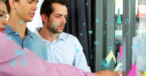 Diverse group of friends analyzing data on glass wall Stock Photos