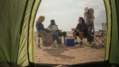 Diverse Group of Friends Camping on Beach Seen from Tent Stock Footage 343243458