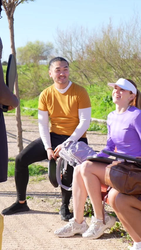 Diverse group of friends resting after playing pickleball Stock Footage 334009818
