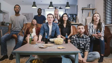 Diverse group get upset watching sports on TV. Football fans sad and emotional Stock Footage 87295852