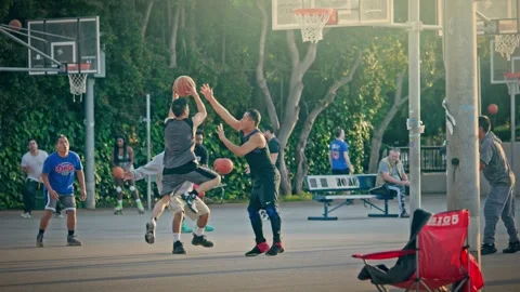 Diverse group hispanic players playing basketball in Poinsettia Park at sunset Stock Footage 277232995