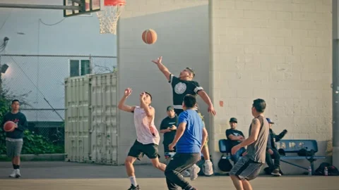Diverse group hispanic players playing basketball in Poinsettia Park at sunset Stock Footage 277290158