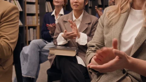 Diverse Group of Listeners Clapping During Book Presentation in Library Stock Footage 329242261