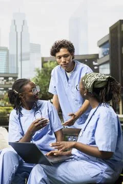 Diverse group of med school sharing notes on laptop during study session Fotos de archivo