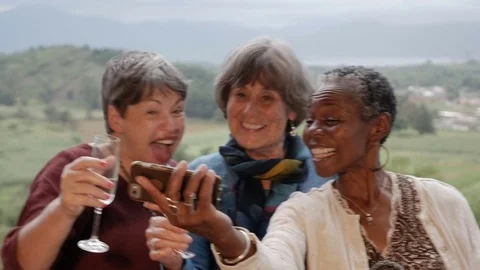 Diverse group of multi racial senior women take a selfie with smartphone Stock Footage