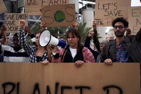 Diverse group of people gathered to protest against factories and environmental Stock Photos
