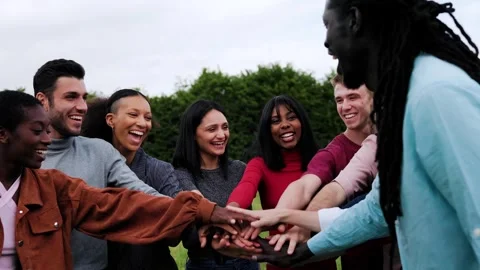 Diverse group of people having fun stacking hands together at park city Stock Footage 305707402