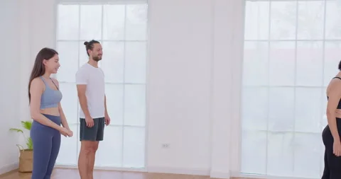 Diverse group of people learn proper posture and alignment from an instructor Stock Footage 344884400