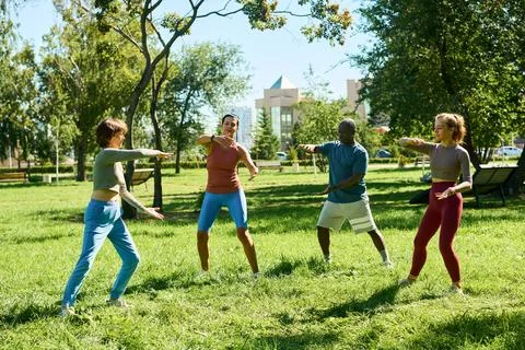 Diverse Group Practicing Tai Chi Exercise in Public Park Foto stock