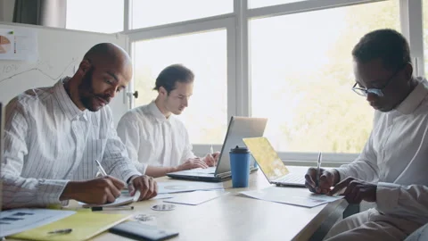 A diverse group of professionals collaborates on crypto trading strategies in a Vídeos de archivo 335731779