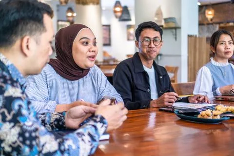 Diverse group of professionals collaborating during a meeting in a modern c.. Stock Photos