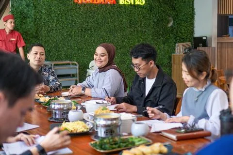 Diverse group of professionals having a working lunch meeting at a restaurant 스톡 사진