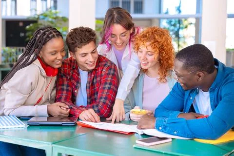 Diverse group of students collaborating at table Stock Photos