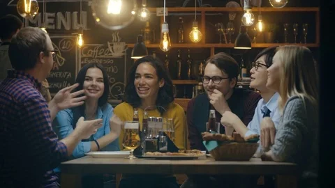 Diverse Group of Young People Have Fun in Bar, Talking, Telling Stories and Joke Stock Footage