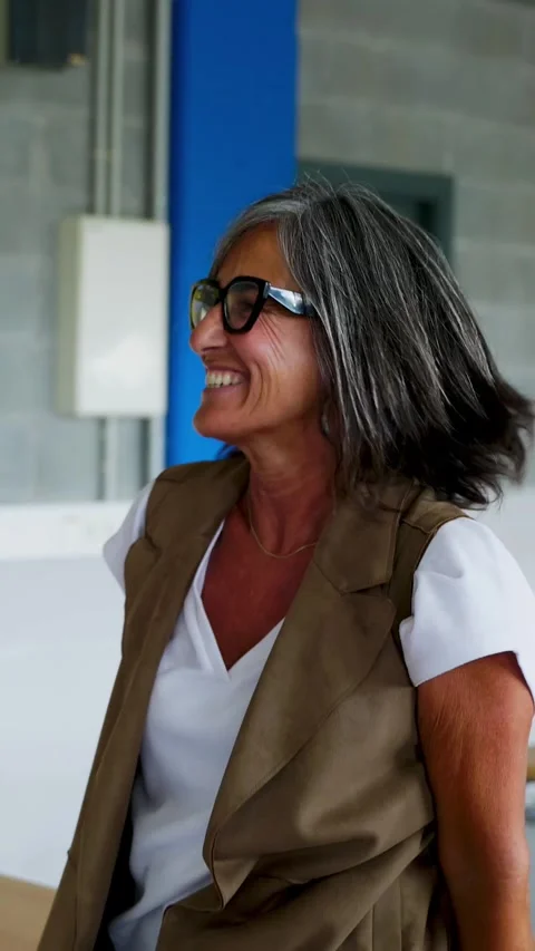 Diverse group of young students stacking hands with female teacher in classroom Stock Footage 310780063