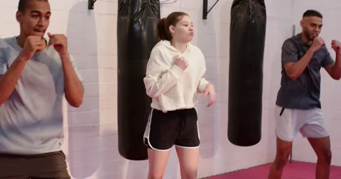Diverse gym-mates bouncing and throwing jab-cross punches with torso rotation on Vidéo 344330571