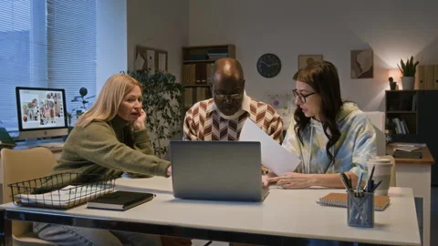 Diverse Intergenerational Team Discussing Documents at Office Desk Stock Footage 328608977