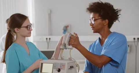 Diverse interns learning to use defibrillator for patient resuscitation Stock Footage 150631273