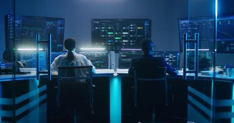 Diverse IT technical specialists work on computers in monitoring office 스톡 사진