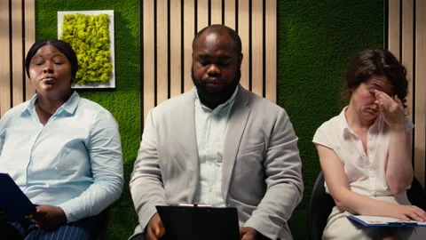 Diverse job seekers sitting in queue on the hallway with CV files Stock Footage 318260995