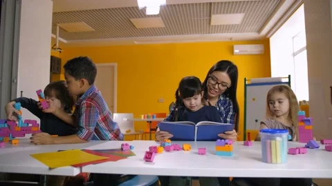 Diverse kids with teacher learning in classroom Stock Footage