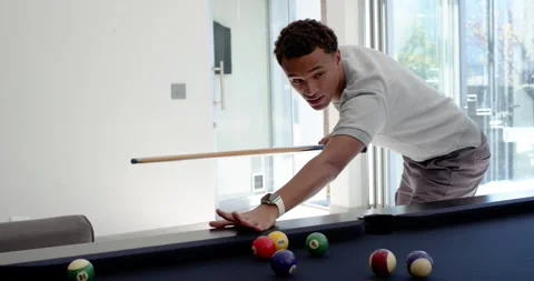 Diverse male friends cheering while lead man leaning over pool table, lining up Stock Footage 342032522