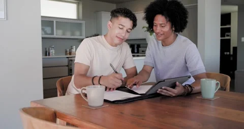 Diverse male pair reviewing folder and tablet pointing signing forms exchanging Stock Footage 337400503