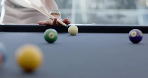 Diverse male players pulling cue, striking white ball at pool table toward right Stock-Footage 342066936