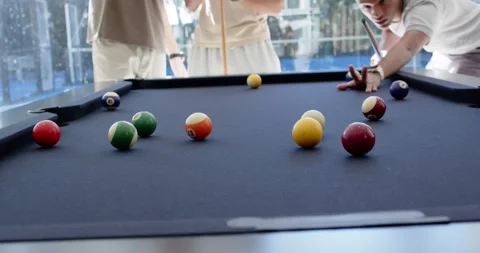 Diverse males at pool table as shooter taking shot, lining cue, hitting cue ball Stock-Footage 342084854