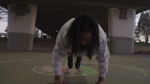 Diverse Man with Dreadlocks Does Burpees Under Bridge at Sundown Stock Footage 270400376