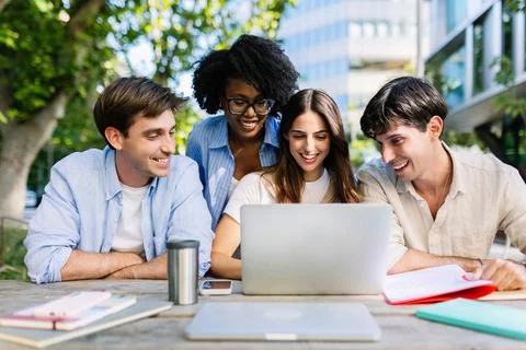 Diverse MBA students studying together with laptop in campus setting Stock Photos